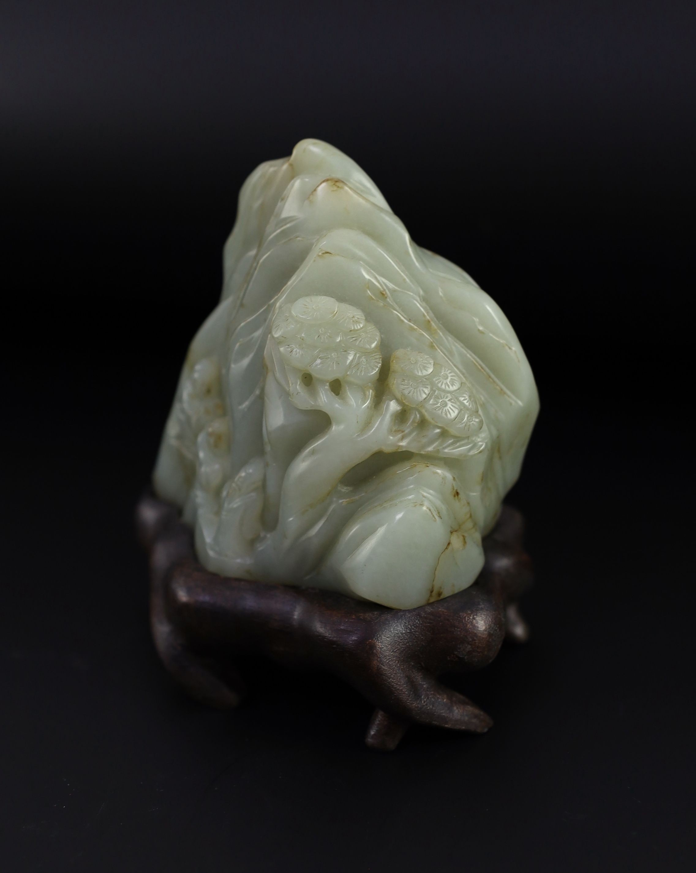 A Chinese pale celadon jade ‘Sanqing’ boulder carving, 18th century, 9.5cm high, 12 with wood stand